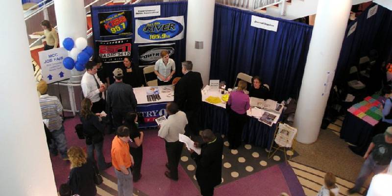 Customers interacting and enquiring about products at stall during a trade show.