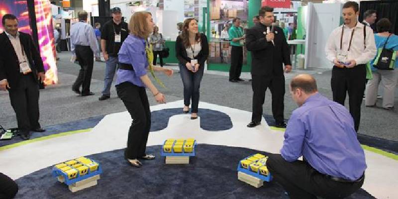 Employees of a company demonstrating their products to customers at a trade show.